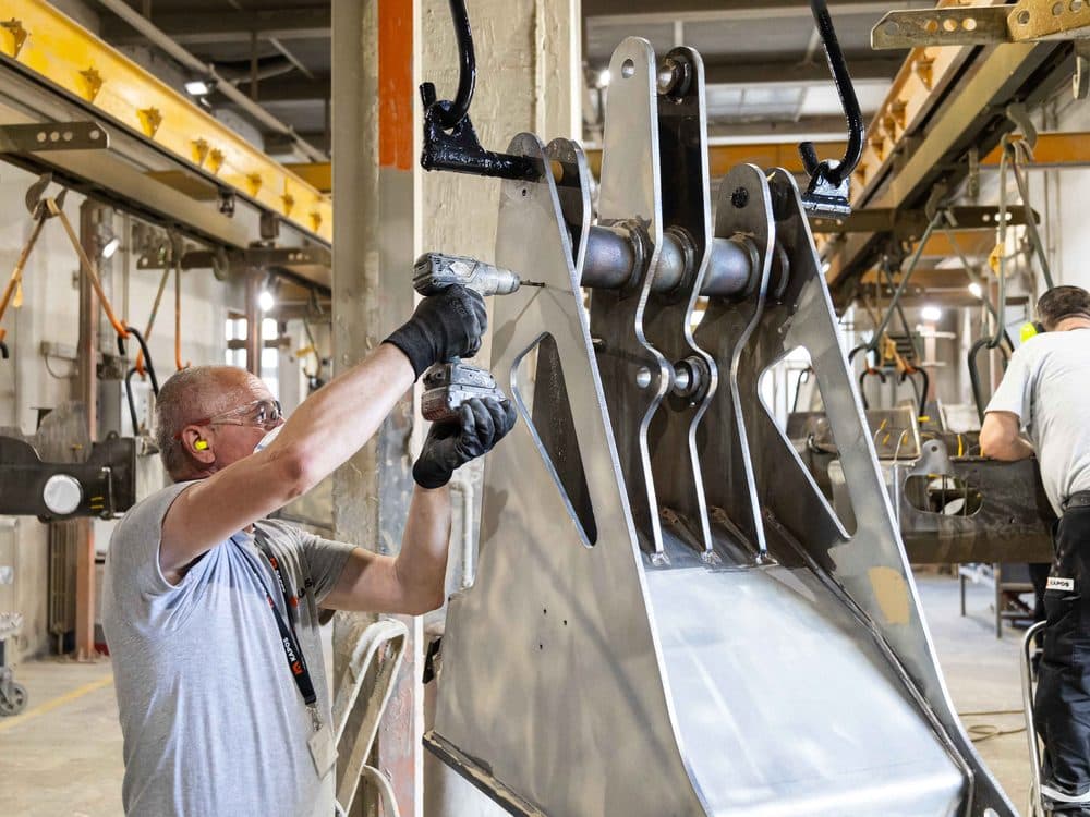 Kapos Atlas worker assembling an excavator attachment
